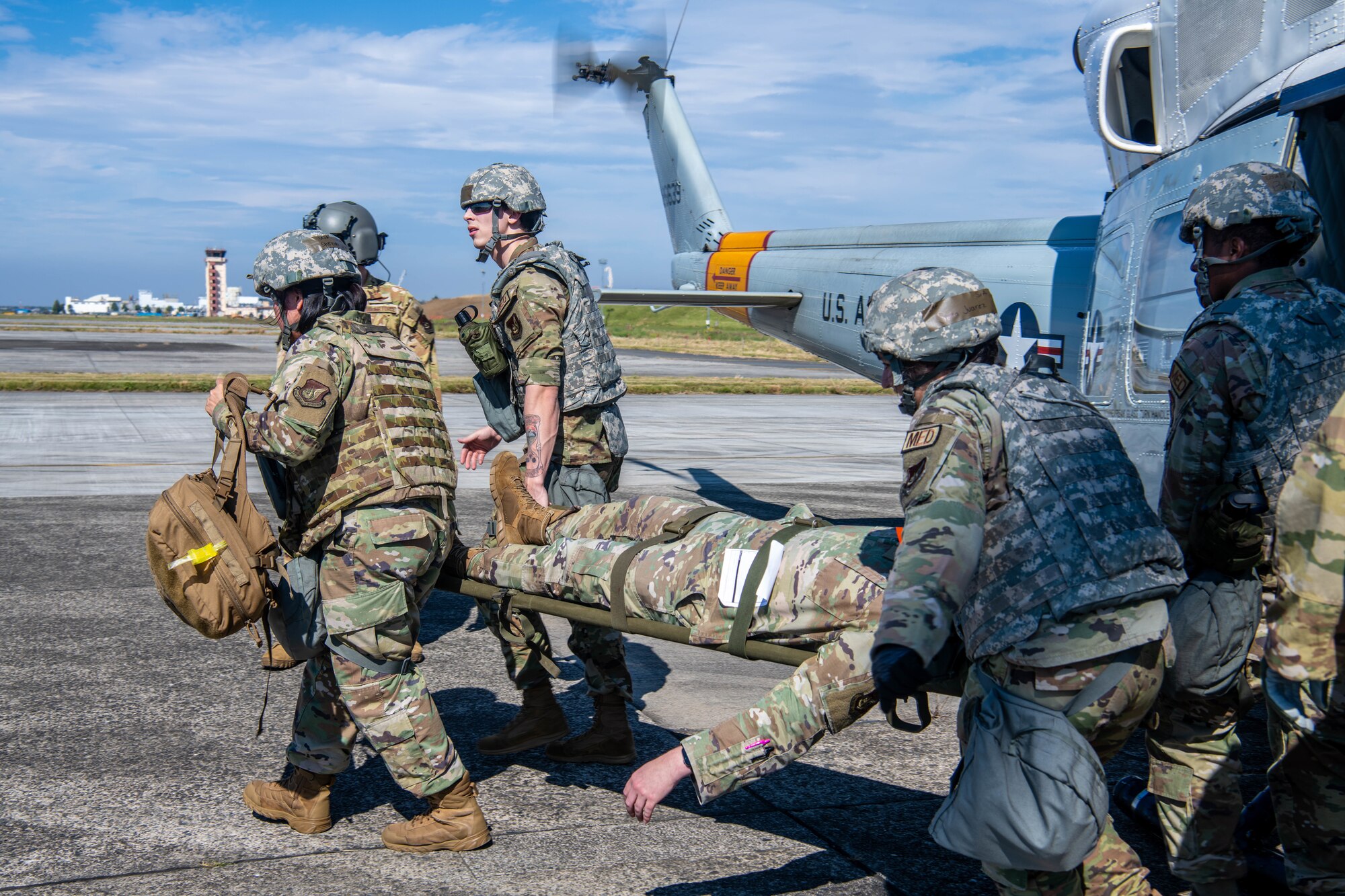 Airmen from the 374th Medical Group evacuate a simulated patient from a helicopter