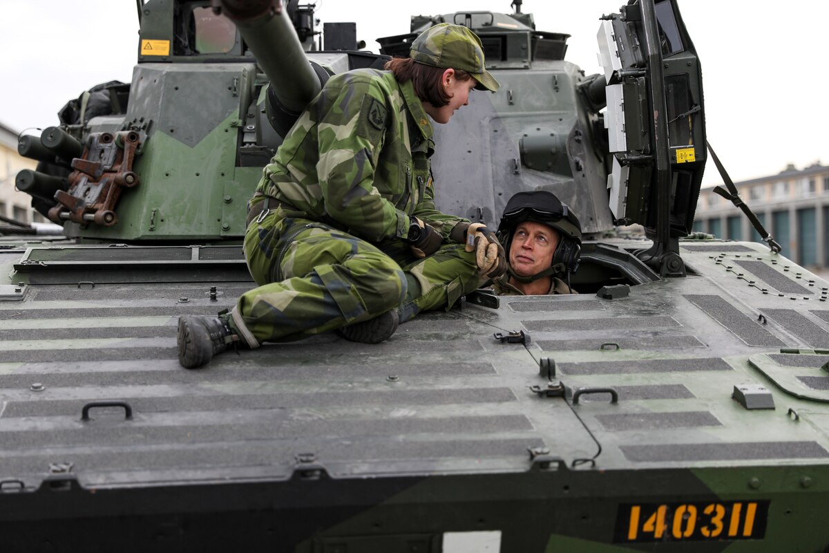 Army Gen. Daniel Hokanson, chief of the National Guard Bureau, talks with a Swedish Armed Forces officer from the driver's seat of a CV9040, Boden, Sweden, Oct. 17, 2023.
