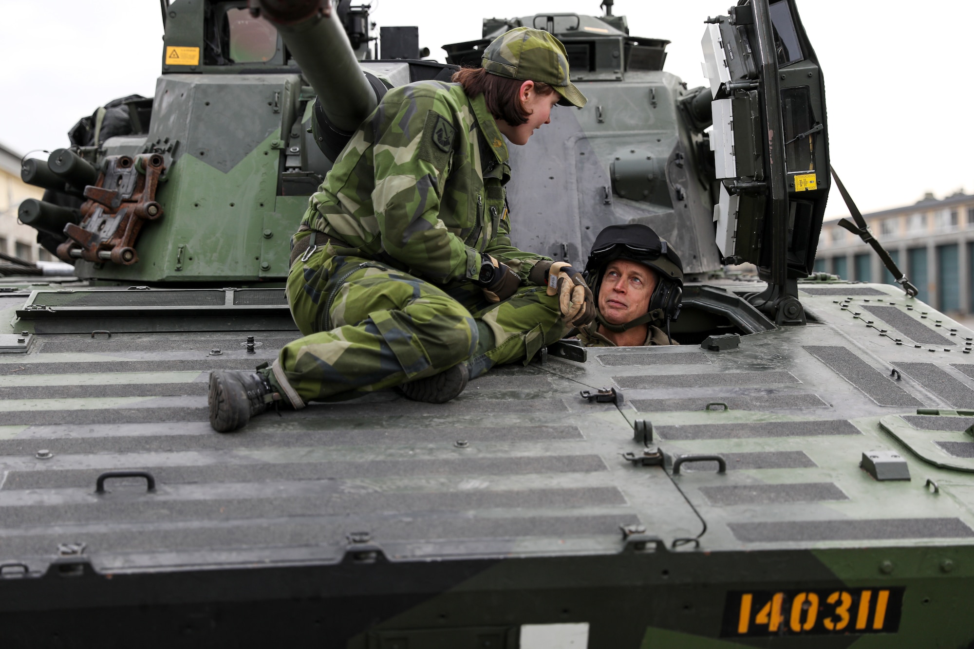 Army Gen. Daniel Hokanson, chief of the National Guard Bureau, talks with a Swedish Armed Forces officer from the driver's seat of a CV9040, Boden, Sweden, Oct. 17, 2023.