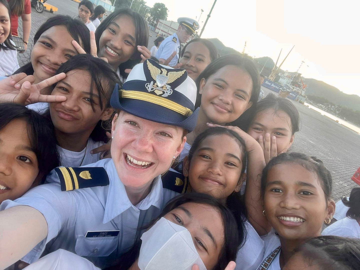 Lt. j.g. Mary Sims, executive officer of USCGC Frederick Hatch (WPC 1143), takes a photo with children at Bliss Elementary School in Tacloban, Philippines, on Oct. 21, 2023. In a historic first, the USCGC Frederick Hatch (WPC 1143) visited Tacloban, Philippines, from Oct. 19 to 23, 2023, and the crew conducted engagements marking a significant milestone in the enduring relationship between the United States and the Philippines. (U.S. Coast Guard photo by Lt. j.g. Mary Sims)