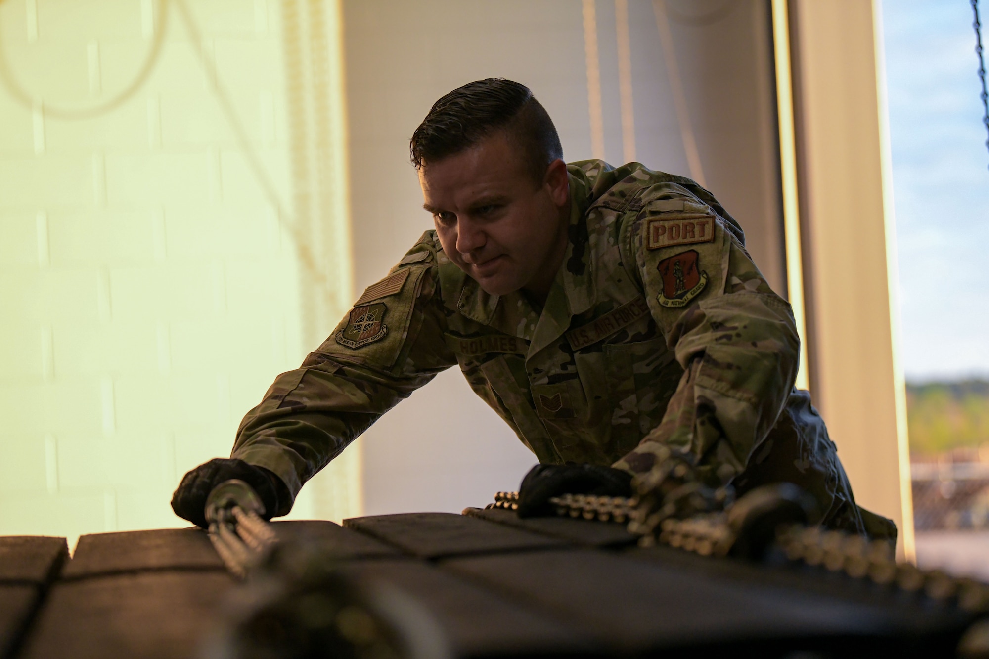 Tech. Sgt. Adam Holmes, an air transportation specialist with the 172nd Logistic Readiness Squadron, prepares to inspect pallets used to transport equipment aboard a C-17 Globemaster III. Holmes, a volunteer firefighter known for his leadership and selfless service, recently applied his skillset and servant mentality to assist a stranded driver when no one else would. (U.S. Air National Guard photo by Staff Sgt. Jared Bounds.)