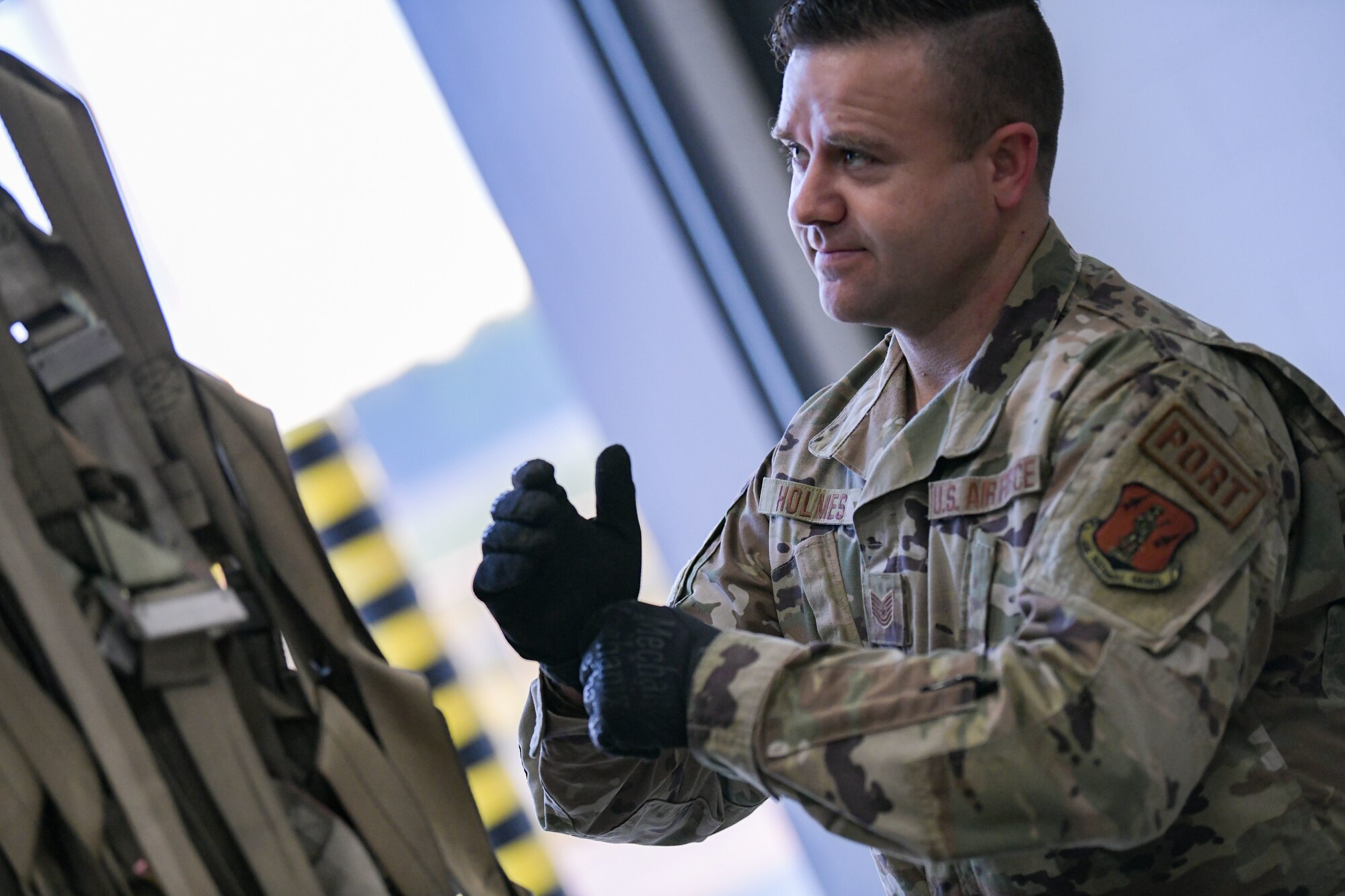 Tech. Sgt. Adam Holmes, an air transportation specialist with the 172nd Logistic Readiness Squadron, prepares to inspect webbing used to transport equipment aboard a C-17 Globemaster III. Holmes, a volunteer firefighter known for his leadership and selfless service, recently applied his skillset and servant mentality to assist a stranded driver when no one else would. (U.S. Air National Guard photo by Staff Sgt. Jared Bounds.)
