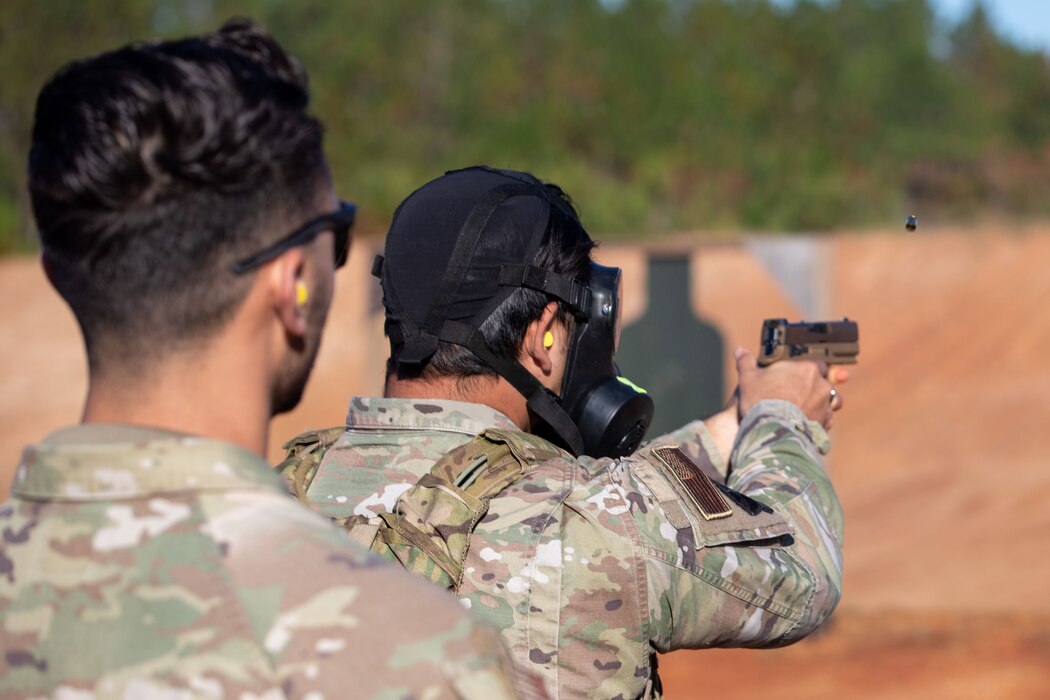 An Airman conducts target firing in a gas mask