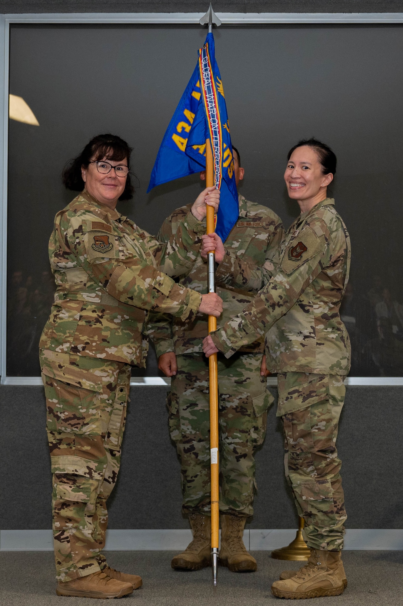 Col. Summer Fields, commander of the 434th Air Refueling Wing, passes the guidon to Lt. Col. Jennifer Fong during an assumption of command ceremony at Grissom Air Reserve Base, Ind., October 15, 2023. Fong assumed command of the 434th Aerospace Medicine Squadron. (U.S. Air Force photo by Airman 1st Class Elise Faurote)