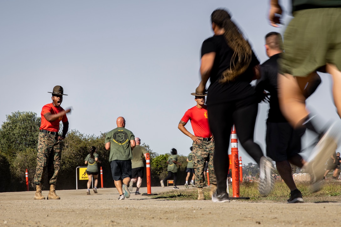 Participants of the Boot Camp Challenge are motivated by drill instructors as they run at Marine Corps Recruit Depot San Diego, Oct. 21, 2023. For the past 21 years the Boot Camp Challenge has offered a unique opportunity to the public to step into the shoes of a future Marine, guided by drill instructors to conquer a three-mile obstacle race and gain experience into what recruits go through during boot camp. (U.S. Marine Corps photo by Sgt. Yvonna Guyette)