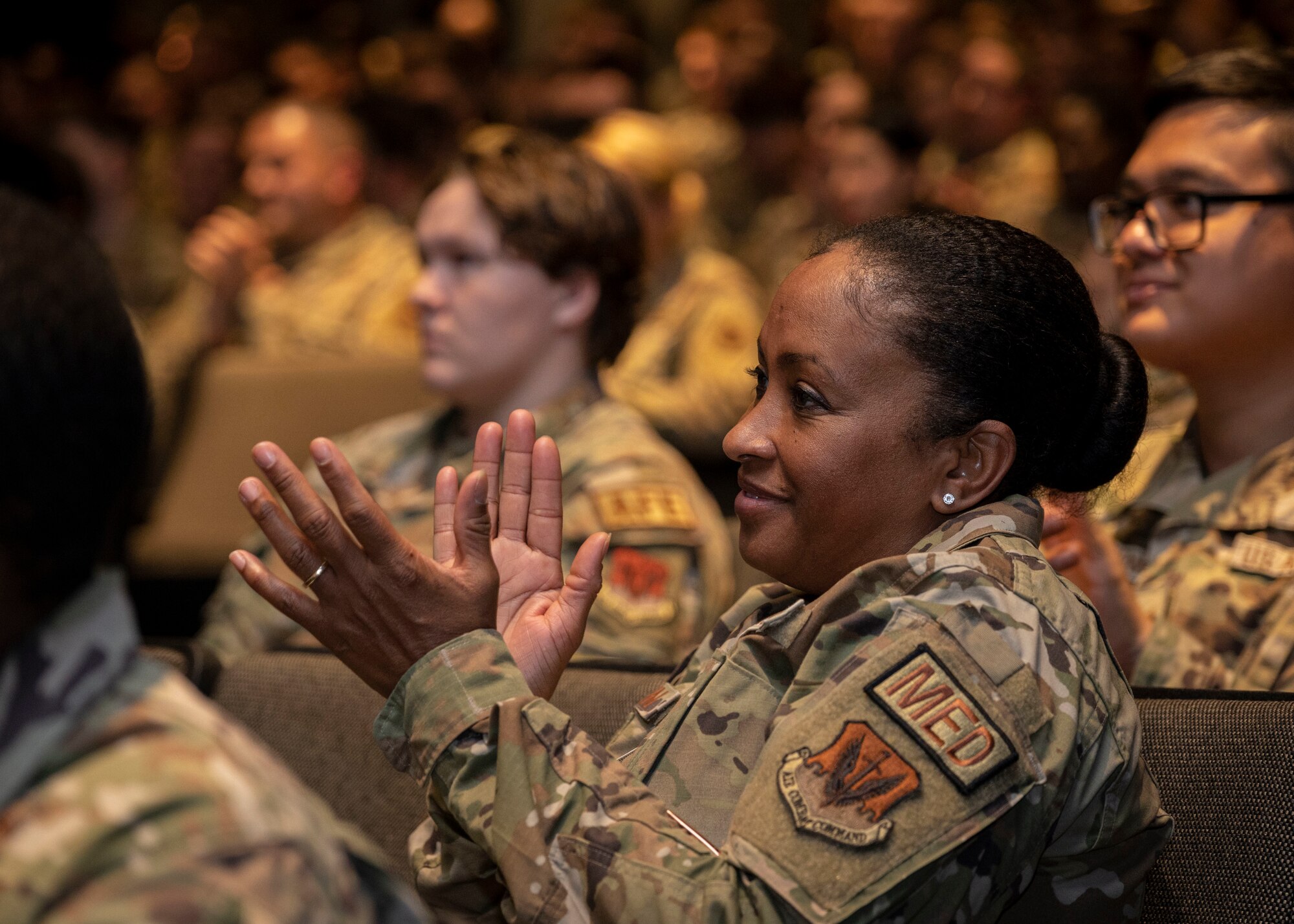 Chief Master Sgt. Kaleah Belin, 4th Medical Group senior enlisted leader, applauds during a commander's all call at Seymour Johnson Air Force Base, North Carolina, Oct. 19, 2023. The all call showcased the accomplishments and improvements needed for personnel to ensure they are ready and adaptable Airmen. (U.S. Air Force photo by Senior Airman Sabrina Fuller)