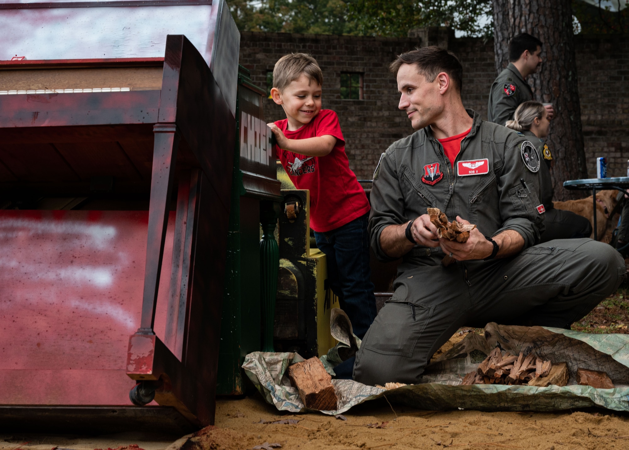 1st. Lt. Charlie Malone, 333rd Fighter Squadron weapons systems officer student, assembles firewood with his son for piano burn during an event in recognition of the Battle of Britain at Seymour Johnson Air Force Base, North Carolina, Oct. 20, 2023. The heritage of the 4th Fighter Wing began with the Royal Air Force Eagle Squadrons in World War II and to commemorate the U.S. ally, the base hosts the Battle of Britain event annually. (U.S. Air Force photo by Senior Airman Sabrina Fuller)