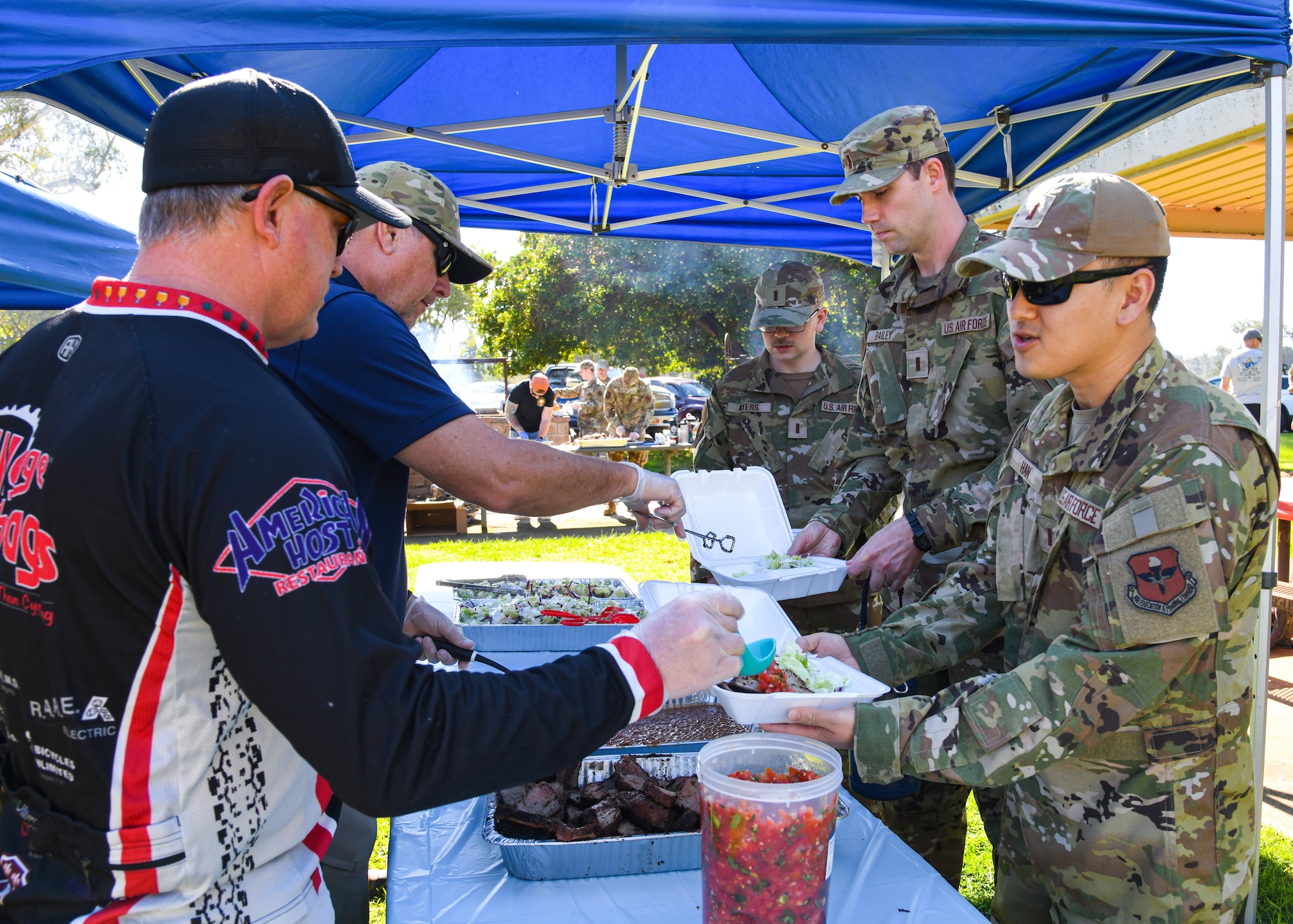 Volunteers from the Military Affairs Committee of the Lompoc Chamber of Commerce serve BBQ brisket to military service members at Cocheo Park at Vandenberg Space Force Base, Calif., Oct. 19, 2023.