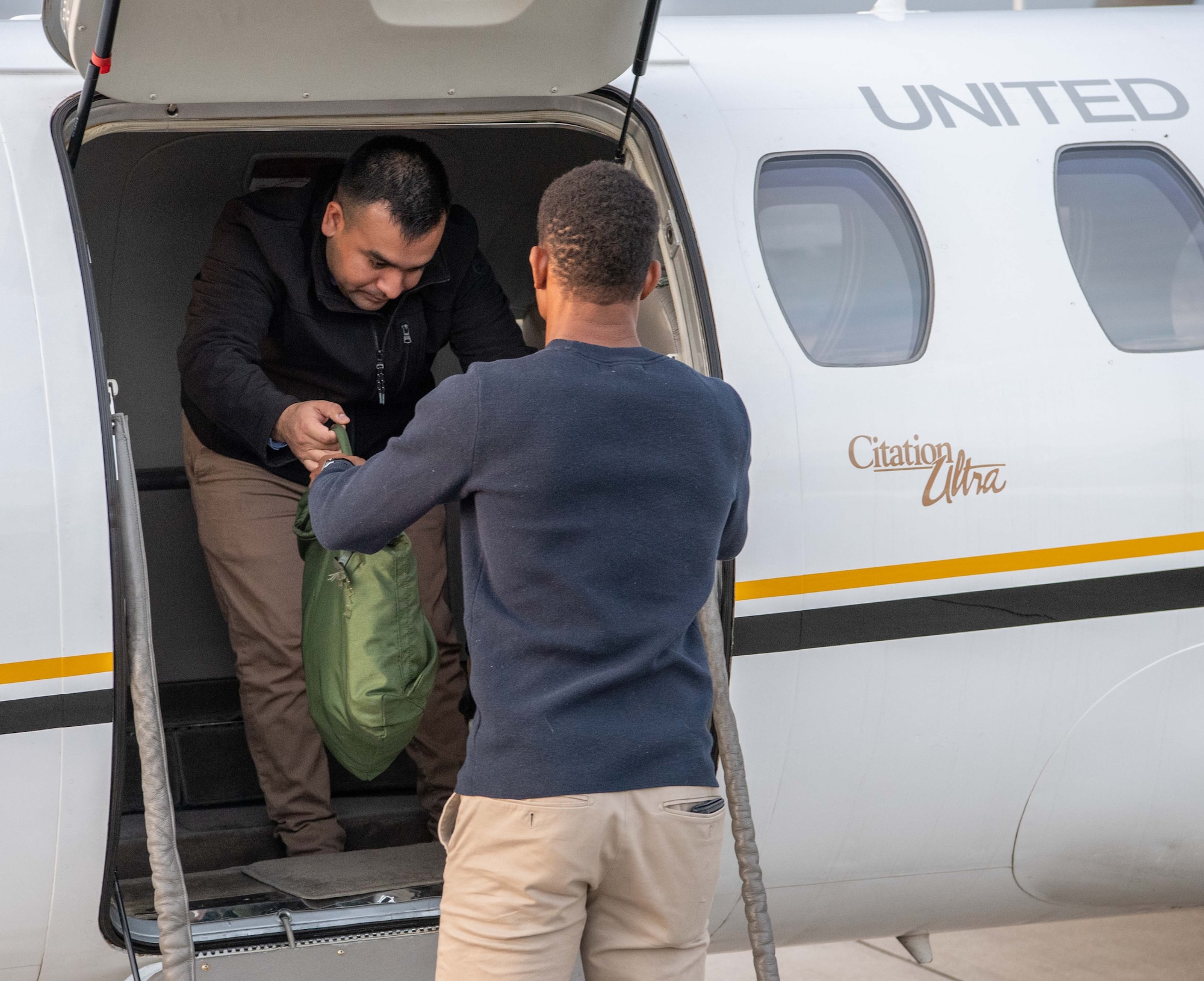 a man hands a bag to another man
