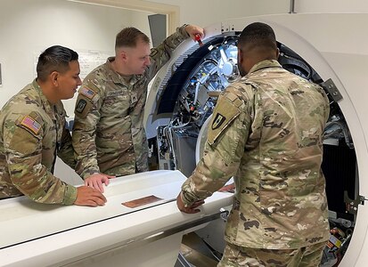 Three biomedical equipment specialists, or 68As, participating in the Army’s medical maintenance Training with Industry program conduct an inspection of a computed tomography, or CT, machine during on-the-job training Oct. 23, 2023. From left, the Soldiers pictured include Sgt. Erick Rodriguez, Staff Sgt. Konnor Grimshaw and Sgt. D’Angelo Brown. The TWI program serves to develop a group of Soldiers experienced in higher level managerial techniques and who understand the relationship of their industry as it relates to specific Army functions. (Courtesy Betsey Meyer)