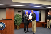 Mr. Douglas Crandall is presented with the 50 Year Fleet Ballistic Missile (FBM) pin Vice Admiral Johnny R. Wolfe, Jr., Director Strategic Systems Programs. The FBM Service Pin Program was established in 1968 as a means of granting special recognition to military, civilian, and contractor personnel who have made significant contributions to the FBM program. These lapel pins are awarded for each decade of creditable service, along with a certificate signed by the Director, Strategic Systems Programs. Fifty years is the longest service length eligible for this recognition. To date, SSP has awarded 53 50 Year FBM pins