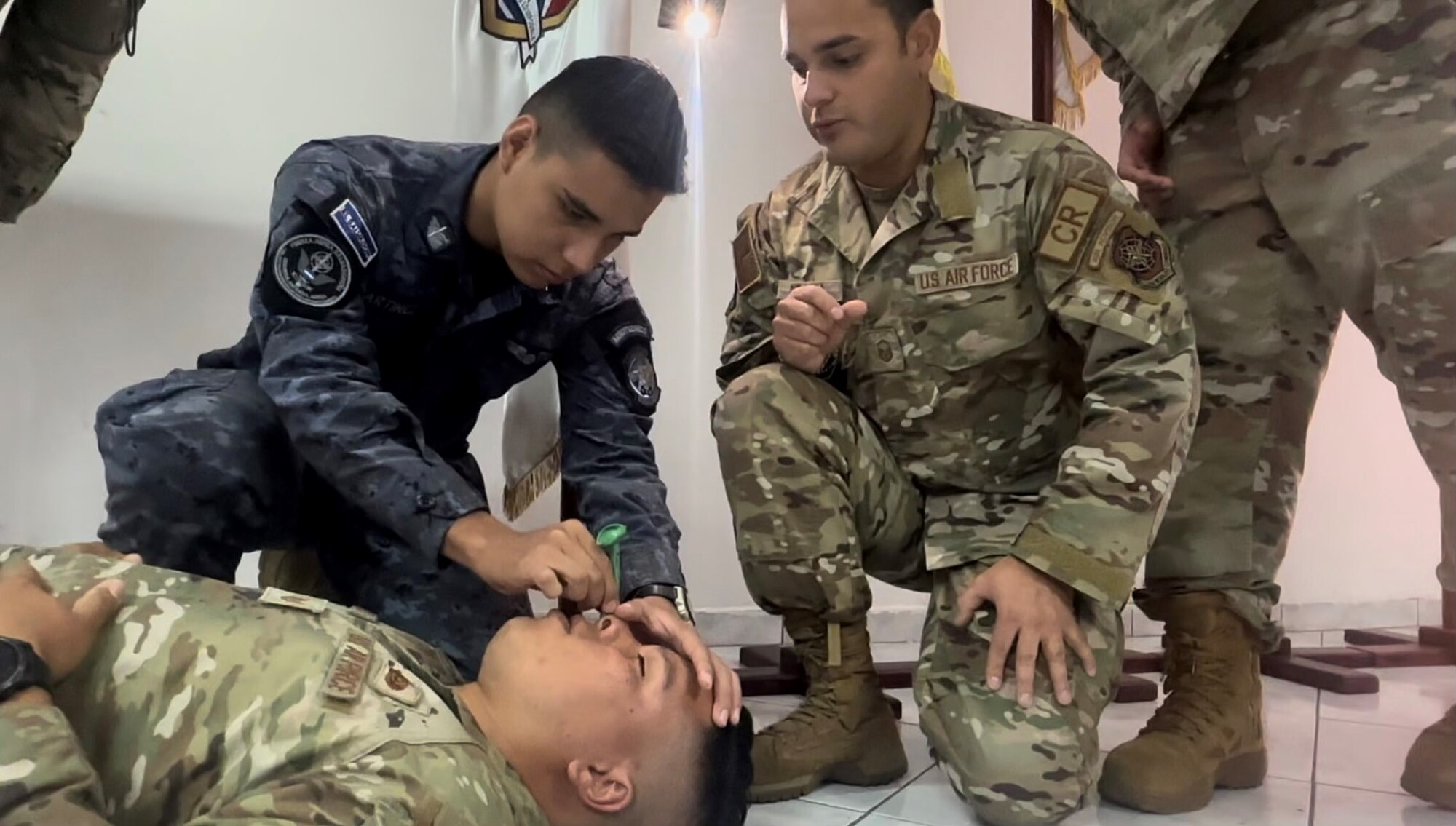 An airman from the Fuerza Aérea Salvadoreña inserts a nasopharyngeal airway device into U.S. Air Force Staff Sgt. Jorge Duarte’s nostril as Master Sgt. Steven Correa supervises while training on Tactical Combat Casualty Care course during El Salvador Mobile Training Team 23-22, Sept. 9, 2023, Ilopango International Airport, San Salvador.