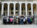 group shot of people on stairs in front of columns