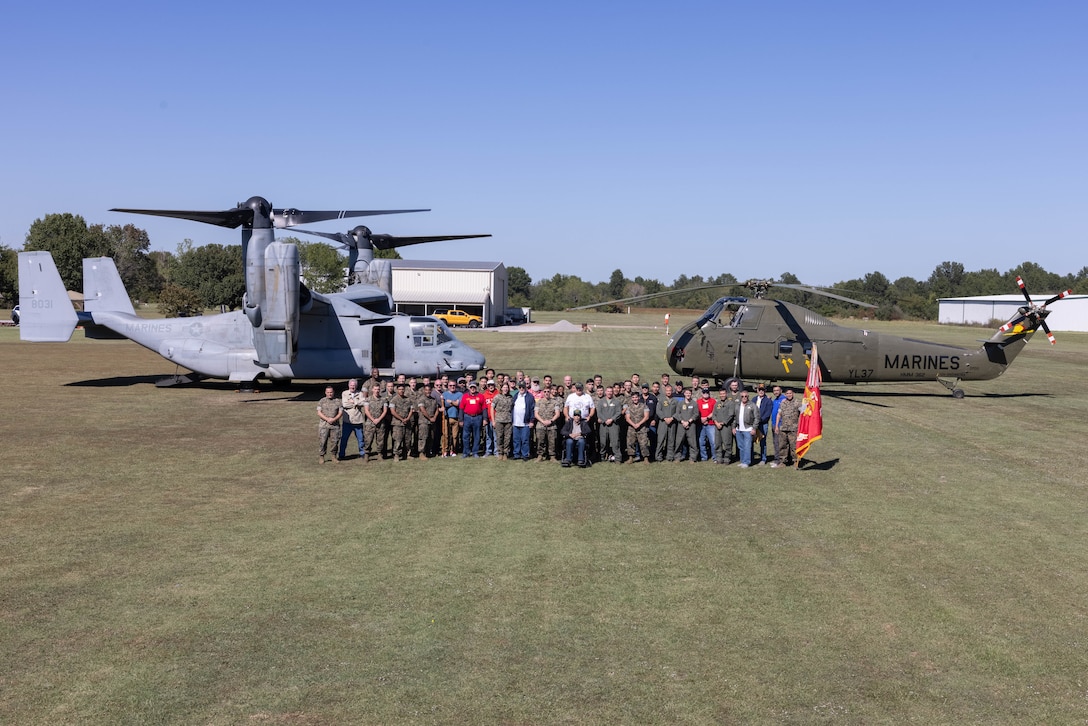 Current and veteran U.S. Marines with Marine Medium Tiltrotor Squadron (VMM) 362, take a photo in front of an MV-22B Osprey with VMM-362, Marine Aircraft Group 16, 3rd Marine Aircraft Wing, and a UH-34 Choctaw during the Ugly Angels Vietnam reunion in Inola, Oklahoma