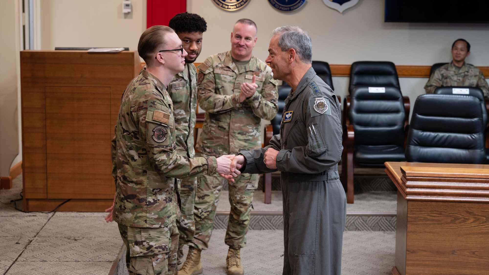 Gen. Ken Wilsbach coins Senior Airman Christopher Smith.