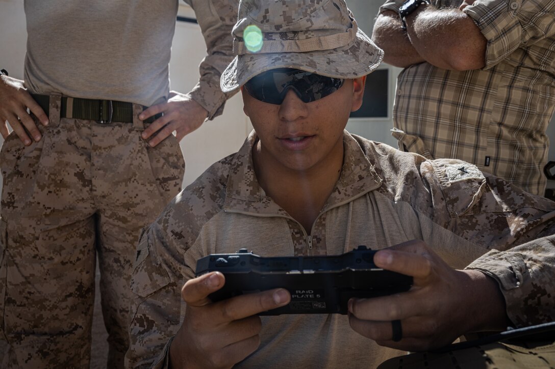 U.S. Marine Corps Lance Cpl. Jeremiah Cottier, a rifleman 3rd Battalion, 4th Marine Regiment, 7th Marine Regiment (REIN), operates a radio agile integrated device during Exercise Apollo Shield at Marine Corps Air-Ground Combat Center, Twentynine Palms, California, Oct. 11, 2023. Exercise Apollo Shield is the culminating event of a 1-year crawl-walk-run bilateral effort to test equipment capabilities and evaluate tactics, techniques, and procedures.
