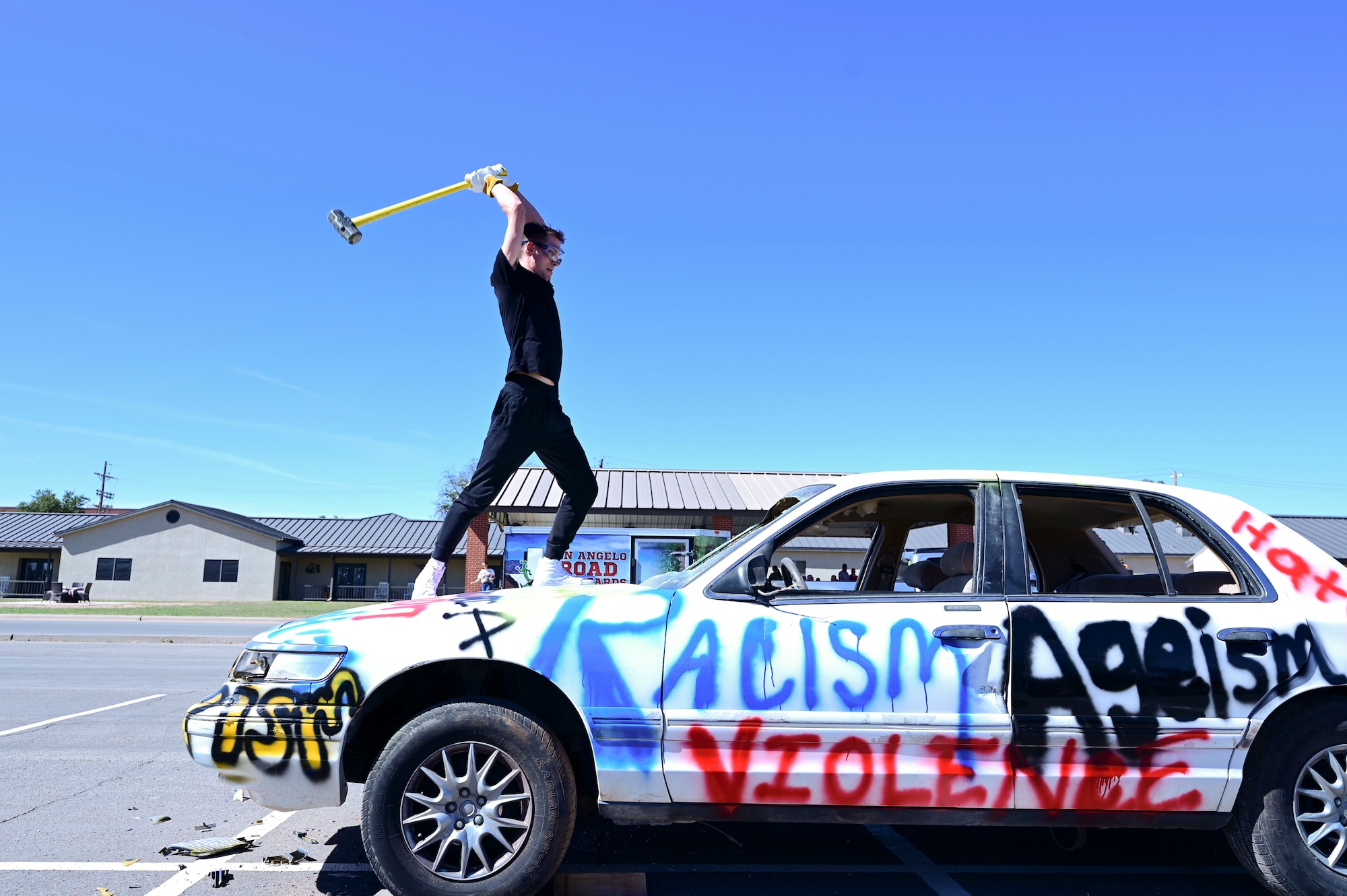 A participant prepares to hit a car during the Diversity, Equity, Inclusion and Accessibility Day: We Belong event at the parade field, Goodfellow Air Force Base, Texas, Oct. 20, 2023. This portion of the event represented the destruction of harmful stereotypes and the rejection of hateful words. The focus of DEIA Day was to highlight the significance of recognizing and embracing the diverse range of personalities and backgrounds within the military. (U.S. Air Force photo by Airman 1st Class Madison Collier)