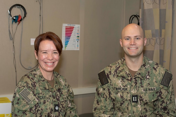 Cmdr. Amy McArthur, a Tucson, Ariz. native and the regional hearing conservation program manager assigned to Naval Medical Forces Atlantic (NMFL) and Lt. Anthony Litwinchuk, a Minneapolis native and audiologist assigned to Navy Medicine and Readiness Training Center (NMRTC) Portsmouth, pose for a photo on board Branch Health Clinic Naval Station Norfolk, Oct. 23 2023.