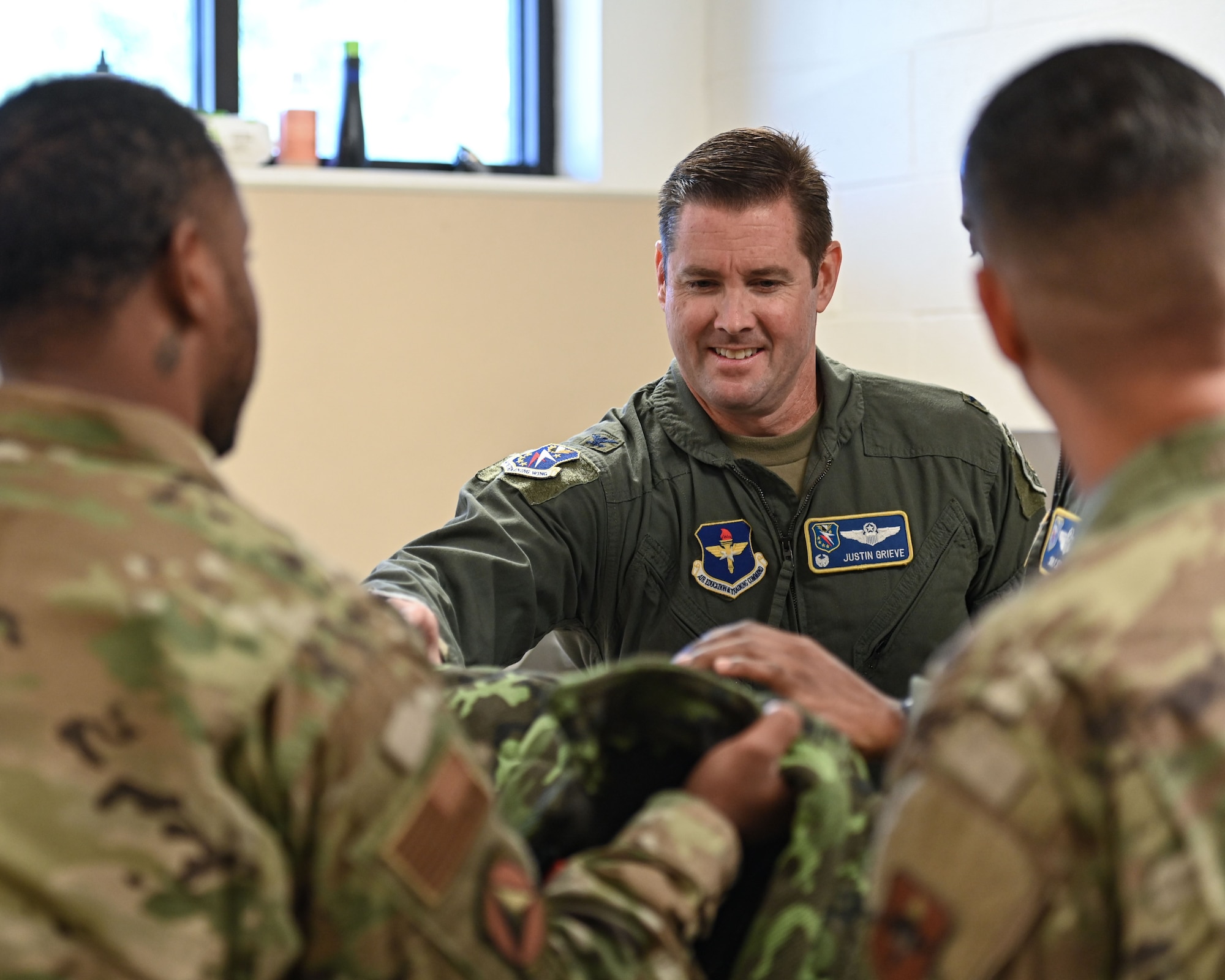 U.S. Air Force Col. Justin Grieve, 14th Flying Training Wing commander, feels the thickness of a protective suit prior to a MWD demonstration at Columbus Air Force Base, MS, Oct. 16, 2023. The 14th Security Forces Squadron gave a tour of the kennels which included a demonstration of the professional gear they adorn during exercises. (U.S. Air Force photo by A1C Jessica Blocher)