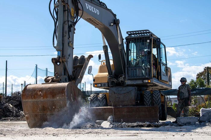 An Airman operates an excavator.