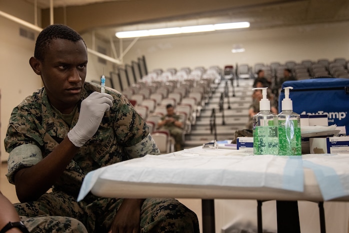 U.S. Navy Seaman Nimrod Ndungu, a hospital corpsman with Marine Aircraft Group (MAG) 24, 1st Marine Aircraft Wing, prepares an annual influenza vaccine for a patient during a shot exercise hosted by Naval Medical Readiness and Training Command Kaneohe Bay Clinic, Marine Corps Base Hawaii, Oct. 5, 2023. The shot exercise, also referred to as SHOTEX, is a medical readiness stand-down held to increase medical readiness by providing vaccinations to military personnel while providing corpsmen the training opportunity to conduct live procedures. (U.S. Marine Corps photo by Lance Cpl. Hunter Jones)