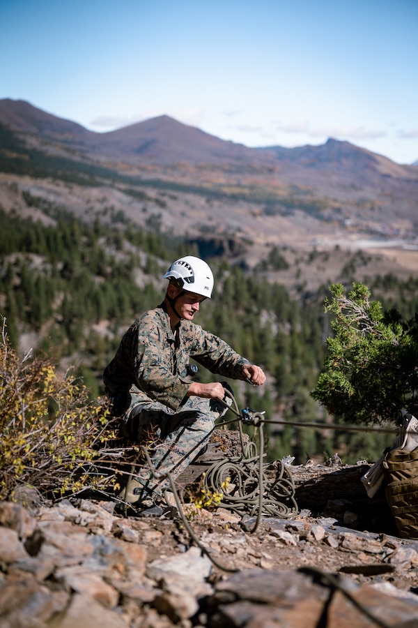 U.S. Marine Corps Cpl. Logan Sauder, a machine gunner with 2nd Battalion, 5th Marine Regiment, 1st Marine Division, tightens a rope while his partner climbs up a cliff face, during Mountain Leaders Course as part of Mountain Exercise 1-24 at MCMWTC, Bridgeport, California, Oct. 11, 2023. MCMWTC specializes in mountain warfare training, providing a unique and ideal opportunity to rehearse operations in a mountainous environment. (U.S. Marine Corps photo by Lance Cpl. Richard PerezGarcia)
