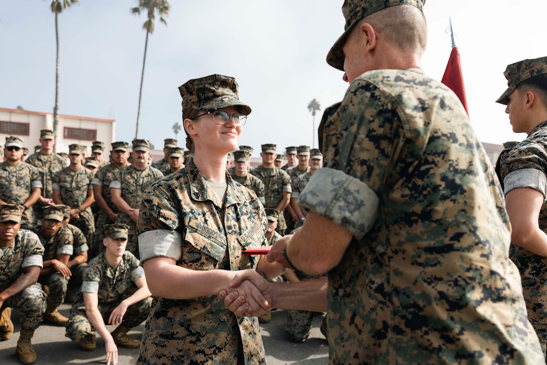 U.S. Marine Corps Cpl. Lydia Dodds, left, an intelligence specialist with Marine Rotational-Force Southeast Asia, I Marine Expeditionary Force, is congratulated by Col. Thomas M. Siverts, commanding officer for MRF-SEA, I MEF, after receiving a Navy and Marine Corps Achievement Medal on Marine Corps Base Camp Pendleton, California, Oct. 20, 2023. The Navy and Marine Corps Achievement Medal is awarded to U.S. service members that demonstrate superior performance and sustained meritorious service in their duties. MRF-SEA is a Marine Corps Forces Pacific operational model which involves planned exchanges with subject matter experts, promotes security goals with Allies and partners, and positions I MEF forces west of the International Date Line. Dodds is a native of Grove City, Pennsylvania. (U.S. Marine Corps photo by Sgt. Shaina Jupiter)