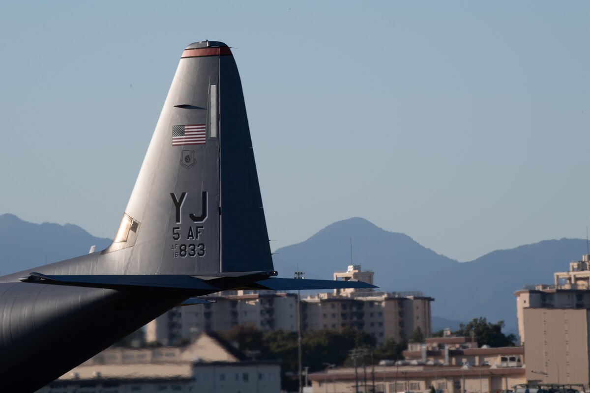The tail of a C-130J Super Hercules and a mountain range