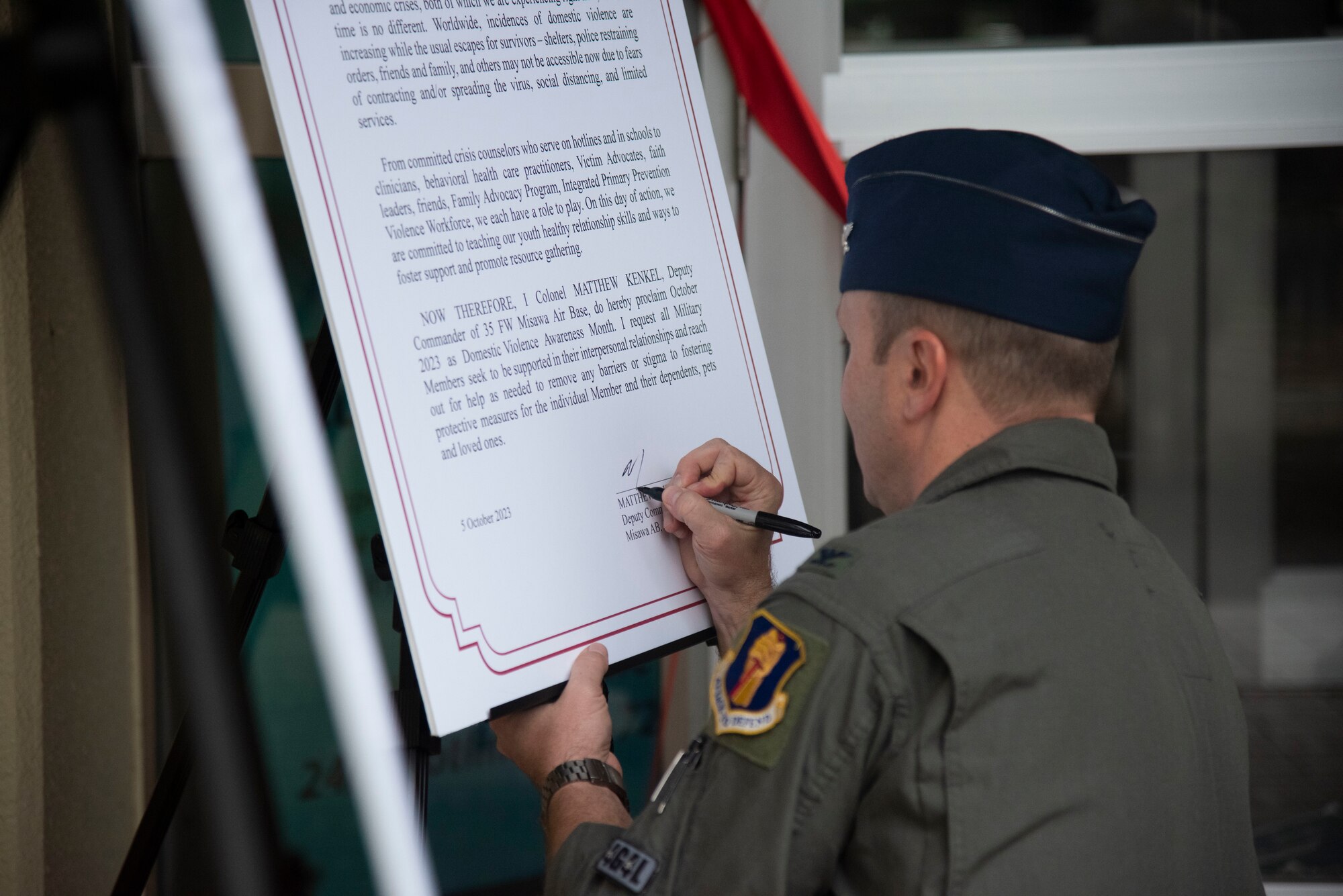 U.S. Air Force Col. Matthew Kenkel, 35th Fighter Wing deputy commander, signs a Domestic Violence Awareness Proclamation during a ceremony at Misawa Air Base, Japan, Oct. 5, 2023.