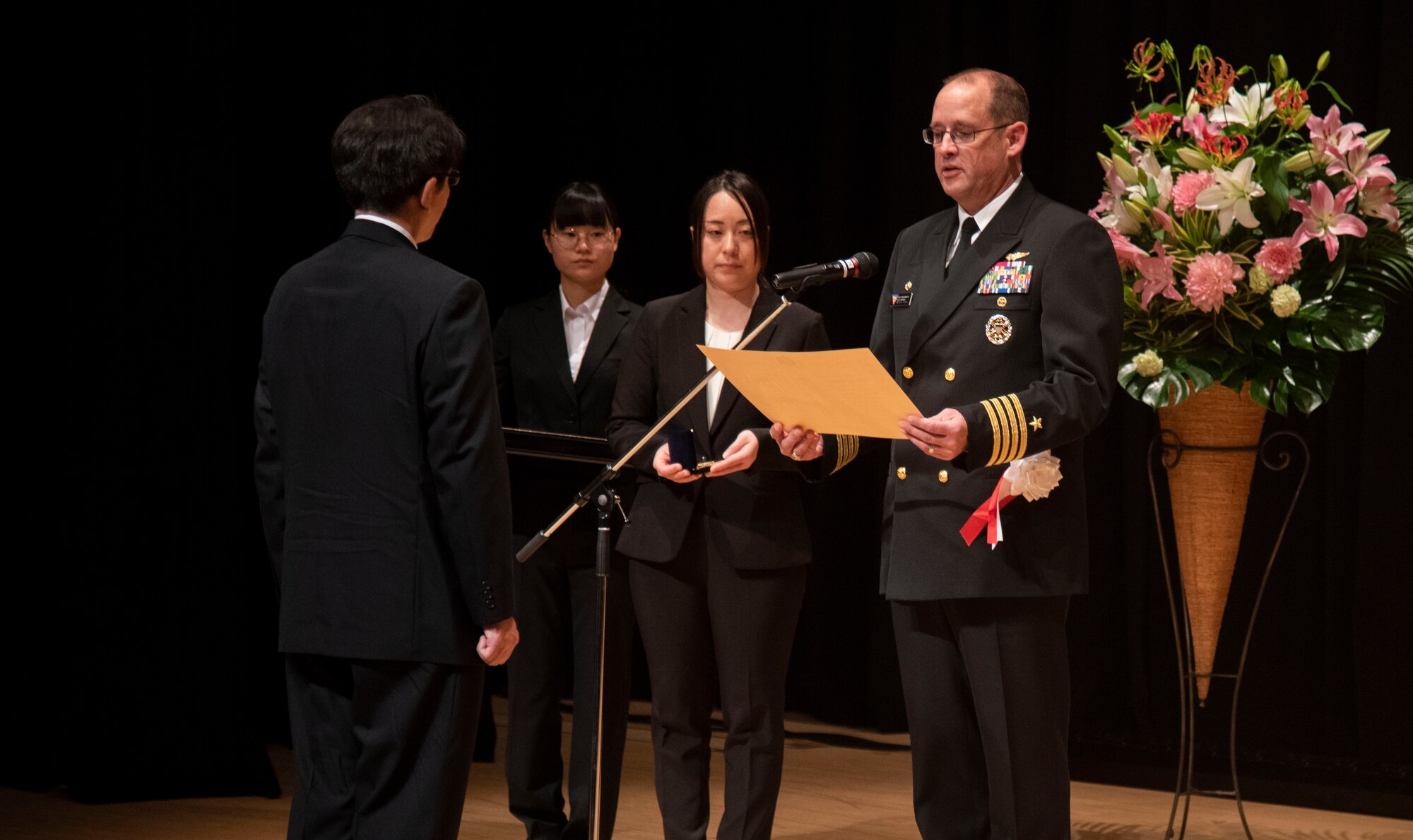 U.S. Navy Capt. Paul Hockran, Naval Air Facility Misawa commanding officer, awards a representative from the master labor contract and indirect hire agreement group during a Length of Service Award Ceremony at Misawa City, Japan, Oct. 20, 2023.