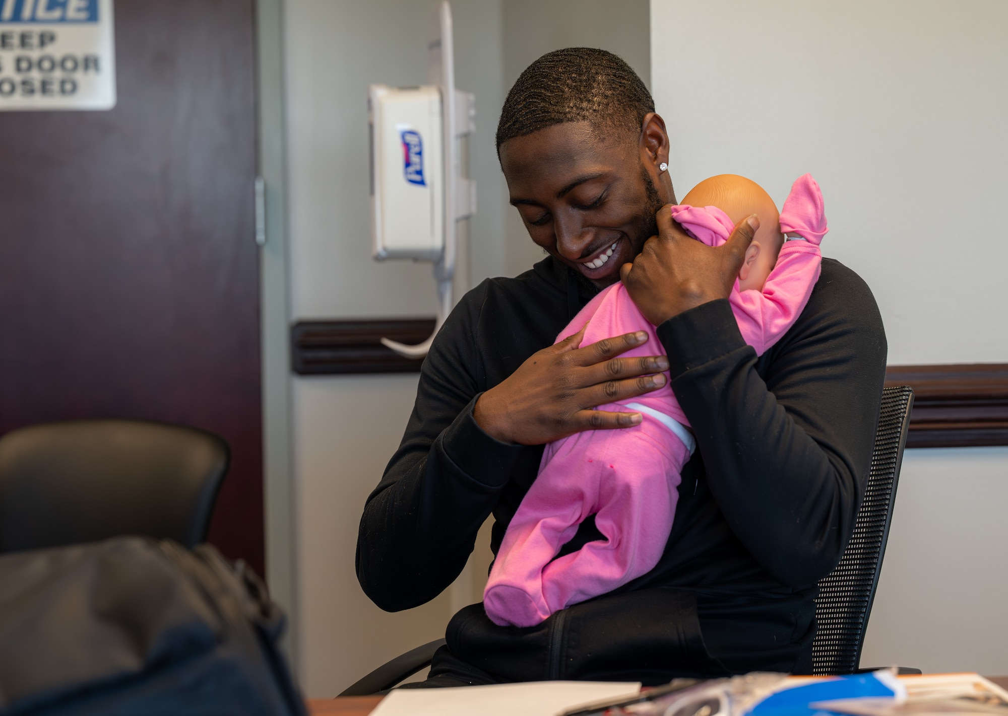 An airman holds a crying doll