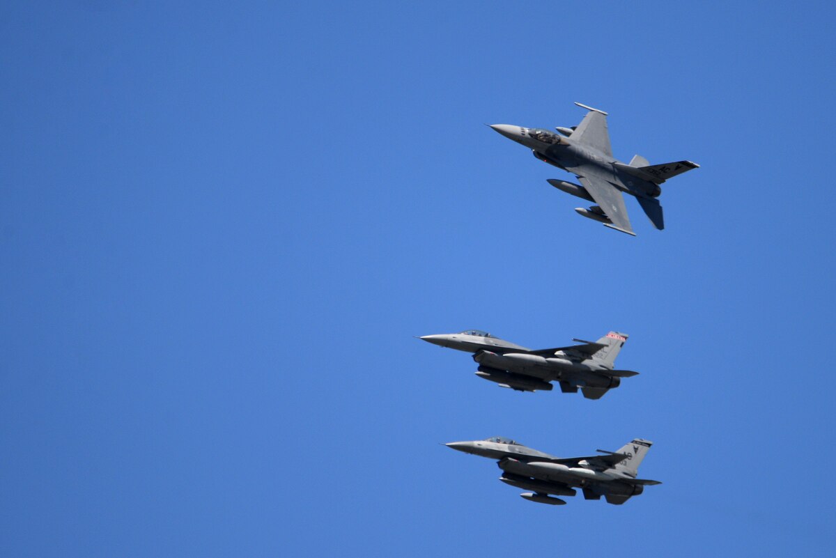 Three fighter aircraft fly against a background of deep blue sky.