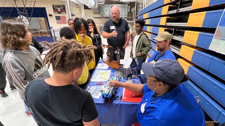 Tiffany Hines, Cody Corlew, and David Chapman share information about careers supporting hydropower and navigation with Antioch Middle School students during a Tennessee STEAM Festival event Oct. 17, 2023, in Antioch, Tennessee. The U.S. Army Corps of Engineers Nashville District partnered with the school to “show and tell” about the many careers related to science, technology, engineering, arts, and mathematics. (USACE Photo by Lee Roberts)