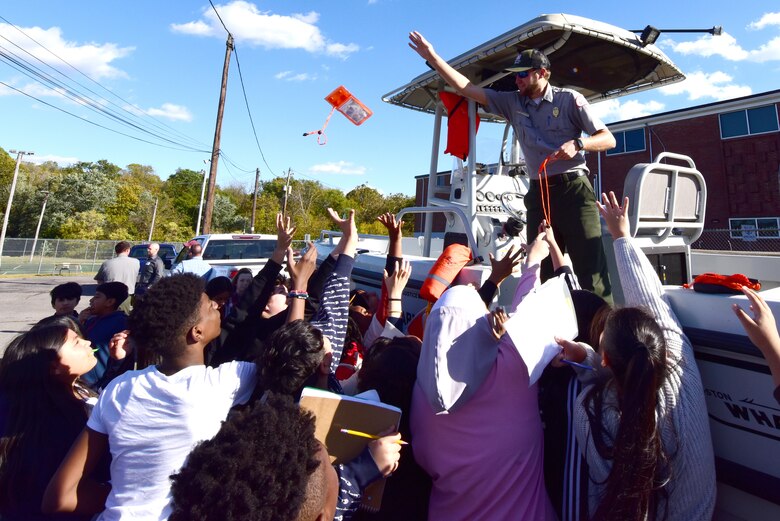 Park Ranger Brad Grems from Cheatham Lake tosses a water safety pouch from a patrol boat to Antioch Middle School students during a Tennessee STEAM Festival event Oct. 17, 2023, in Antioch, Tennessee. The U.S. Army Corps of Engineers Nashville District partnered with the school to “show and tell” about the careers related to science, technology, engineering, arts, and mathematics. (USACE Photo by Lee Roberts)