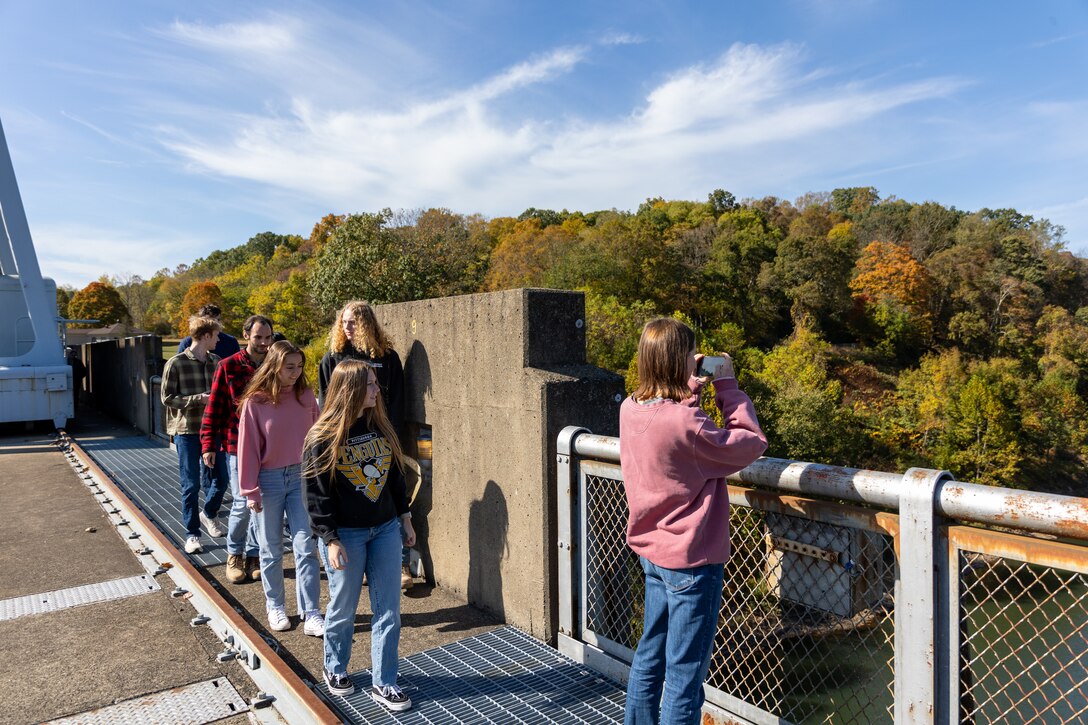 In a convergence of academia and real-world engineering, a group of students from the University of Pittsburgh’s Hydrologic Analysis and Design course explored the Conemaugh River Dam to expand their engineer learning beyond conventional classroom boundaries. Amanda Lee, a student at the University of Pittsburgh, takes a photo of the vista at Conemaugh River Dam as her classmates catch up to her during a visit of the dam in Saltsburg, Pennsylvania, Oct. 13, 2023.