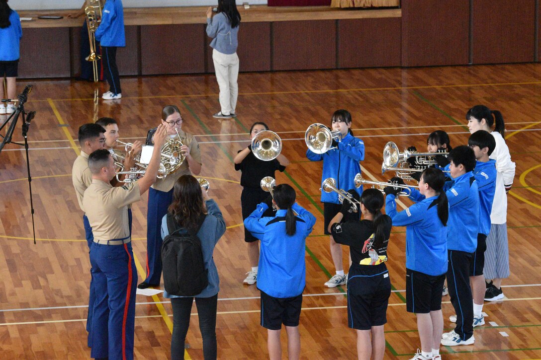 Third Marine Expeditionary Force (III MEF) Band members and Gotemba Nishi Junior High School students rehearse together, October 14, 2023. Marines offered the student musicians advice on how to produce the best sounds with their instruments. The III MEF Band was invited to participate at the Combined Arms Training Center, Camp Fuji Friendship Festival. (U.S. Marine Corps photo by Song Jordan)