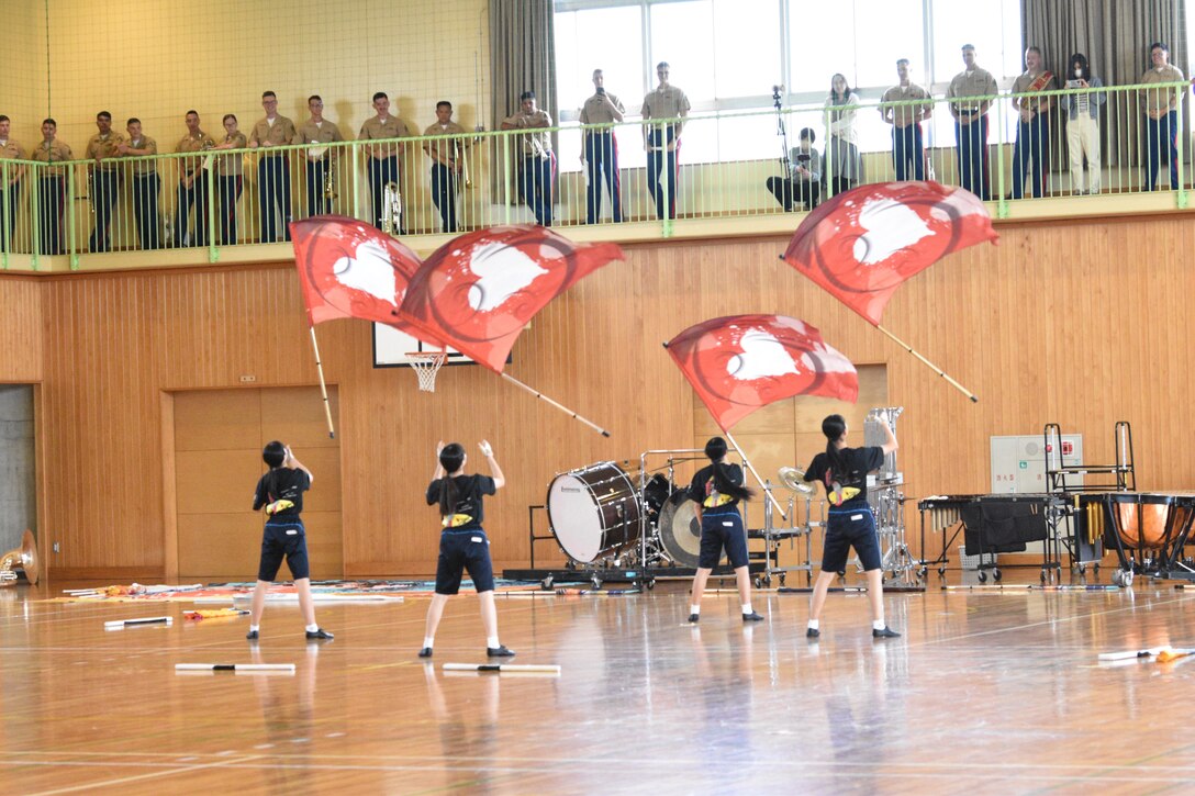 The Third Marine Expeditionary Force (III MEF) Band watches Gotemba Nishi Junior High School drill team members perform, October 14, 2023. The III MEF Band, based in Okinawa, was originally requested to perform at the Combined Arms Training Center, Camp Fuji Friendship Festival. (U.S. Marine Corps photo by Song Jordan)