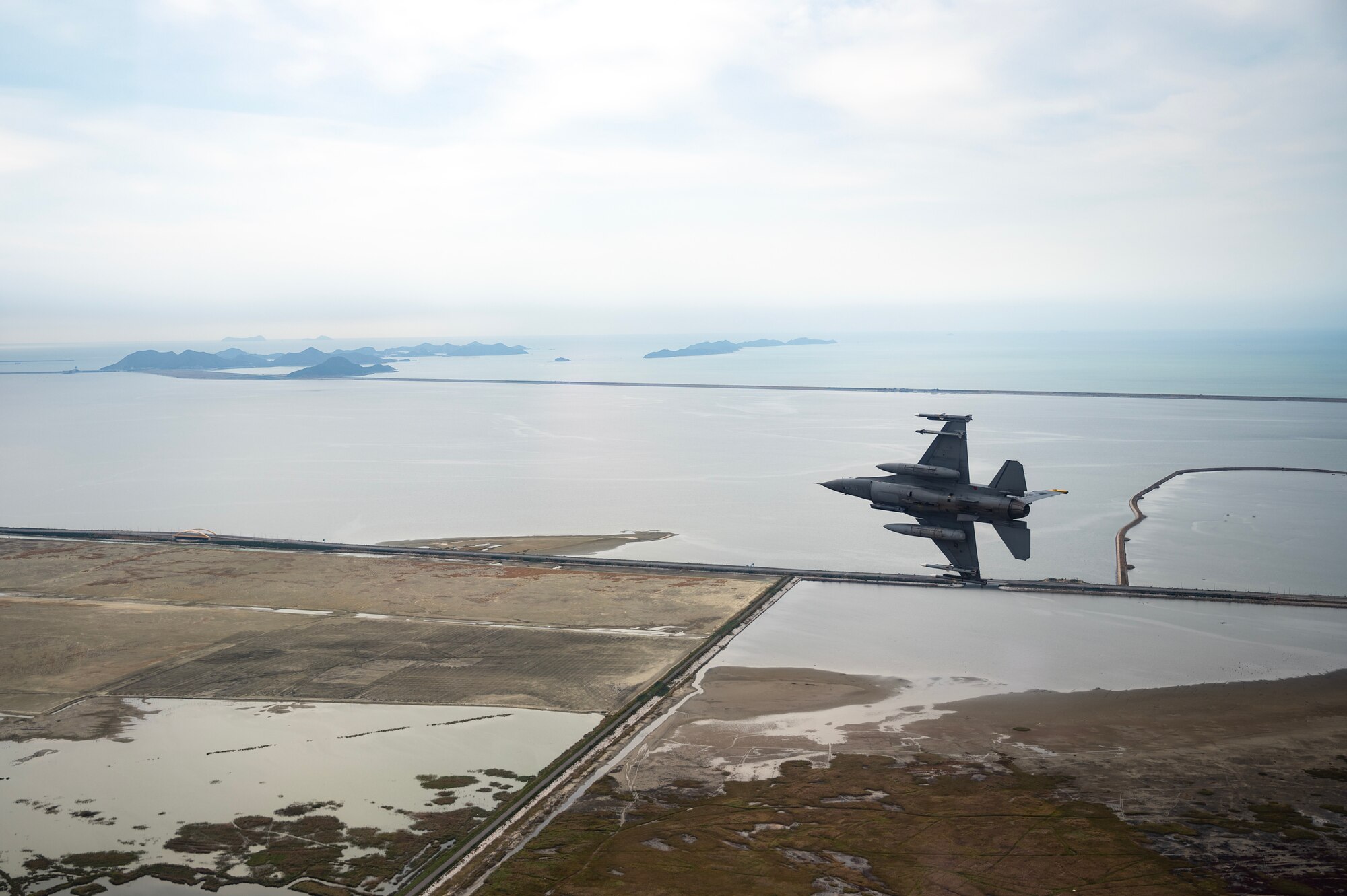 A U.S. Air Force F-16 Fighting Falcon soars over the Republic of Korea's southern coast.