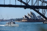The unmanned surface vessel Sea Hunter transits underneath the Sydney Harbor bridge as part of a scheduled port visit during Integrated Battle Problem (IBP) 23.2, Oct 24, 2023. IBP 23.2 is a Pacific Fleet exercise to test, develop and evaluate the integration of unmanned platforms into fleet operations to create warfighting advantages. (U.S. Navy photo by Ensign Pierson Hawkins)