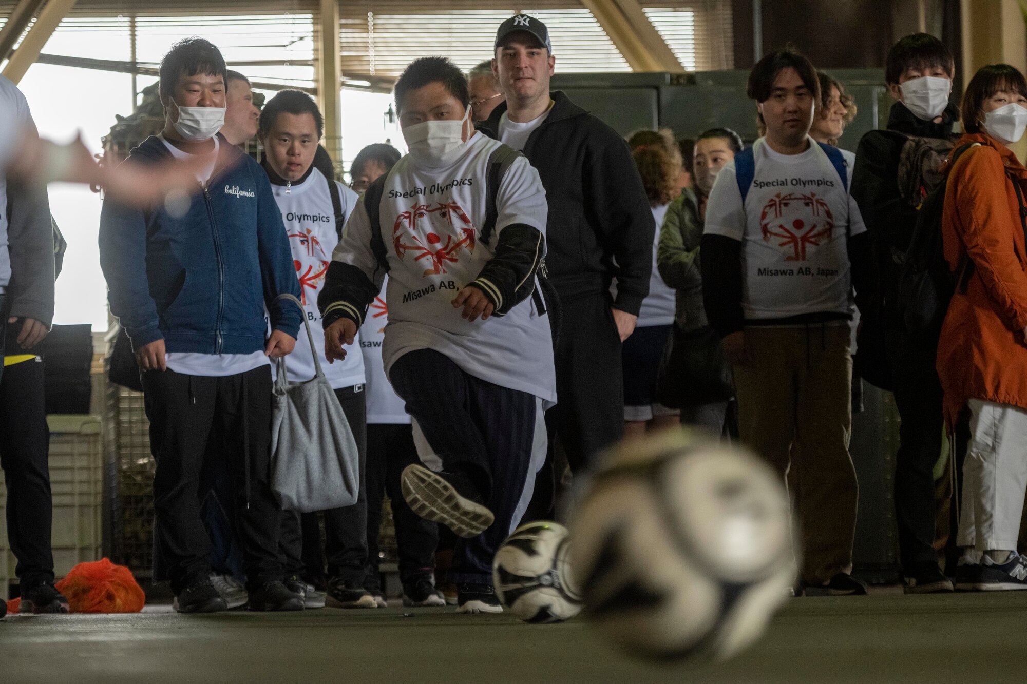 An athlete kicks a soccer ball towards a goal during the 2023 Misawa Special Olympics at Misawa Air Base, Japan.