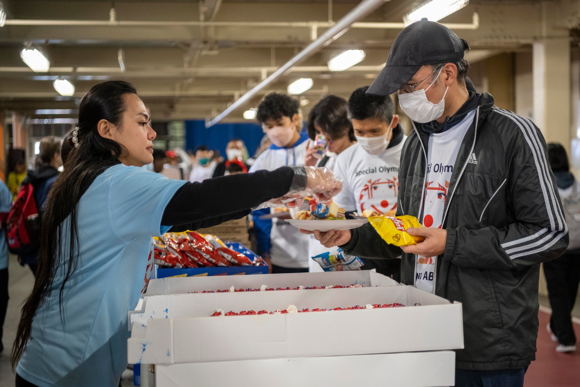A volunteer gives out food to participants during the 2023 Misawa Special Olympics at Misawa Air Base, Japan.