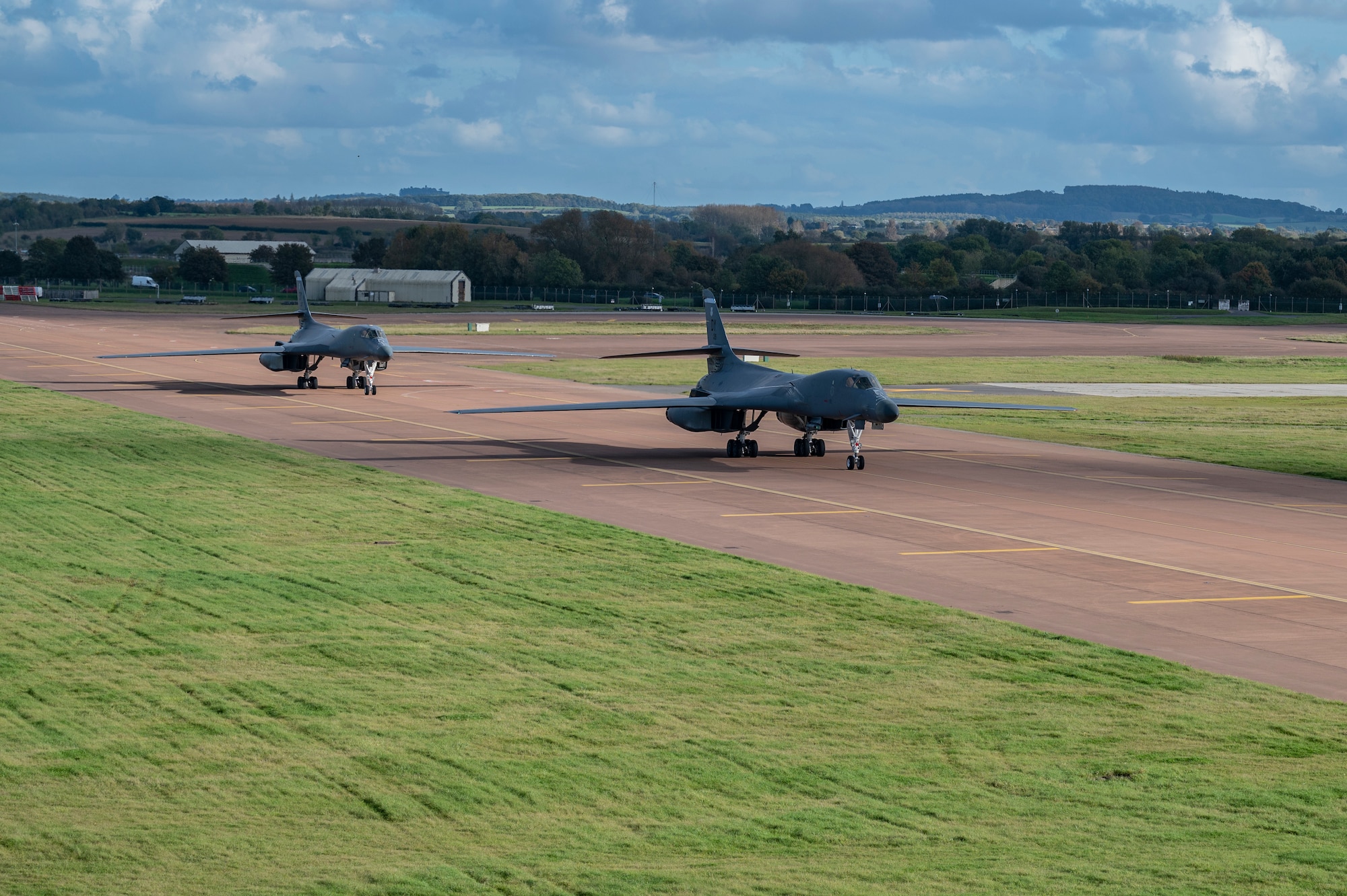 Two B-1B Lancers assigned to the 9th Expeditionary Bomb Squadron taxi on the flightline at RAF Fairford, United Kingdom, Oct. 12, 2023. The U.S. Air Force routinely deploys a variety of aircraft and units throughout Europe for training and to support geographic combatant command objectives. (U.S. Air Force Photo by Senior Airman Ryan Hayman)