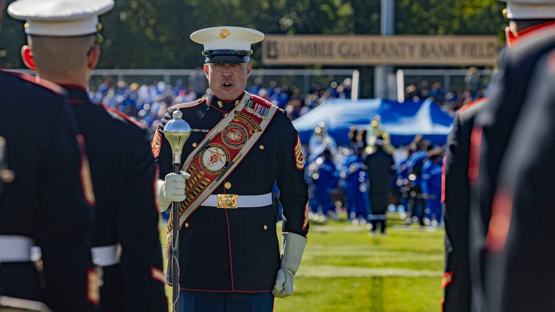 U.S. Marine Corps Gunnery Sgt. Robert Brooks, a musician with the 2d Marine Division (MARDIV) Band, gives a command to the Marines during a halftime performance at the University of North Carolina Pembroke, in Pembroke, North Carolina, September 1, 2023. Community relation events like these enable the Marines of 2d MARDIV to give back to the local community. (U.S. Marine Corps photo by Cpl. Megan Ozaki)