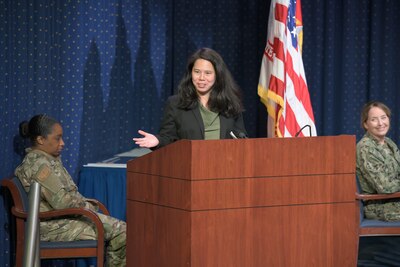 Woman stands behind a podium talking