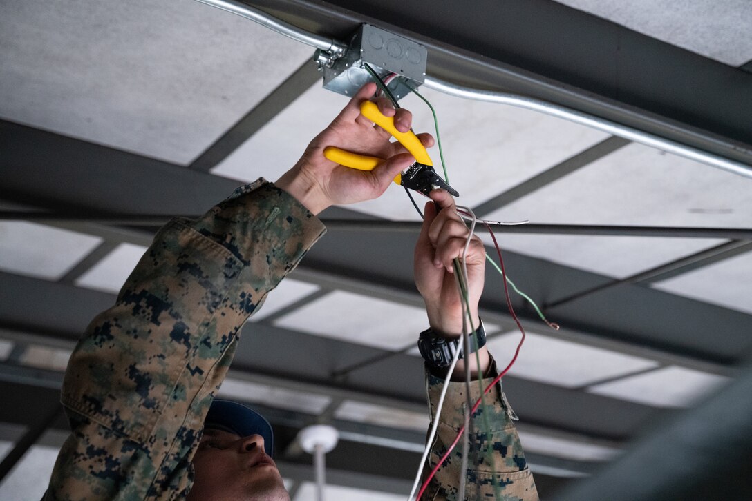 U.S. Marine Cpl. Mitchell Leffler, a refrigeration and air conditioning technician with Marine Wing Support Squadron (MWSS) 471, Engineering Company, installs wiring for an electrical system in support of Northern Lightning 23 at Volk Field Air National Guard Base, Wisconsin, Aug. 11, 2023. Northern Lightning is one of the seven Air National Guard joint accredited readiness exercises that increases military readiness by providing participating units a tactical, joint training environment to execute realistic combat training. Leffler is a native of Onsted, Michigan. (U.S. Marine Corps photo by Cpl. Ujian Gosun)