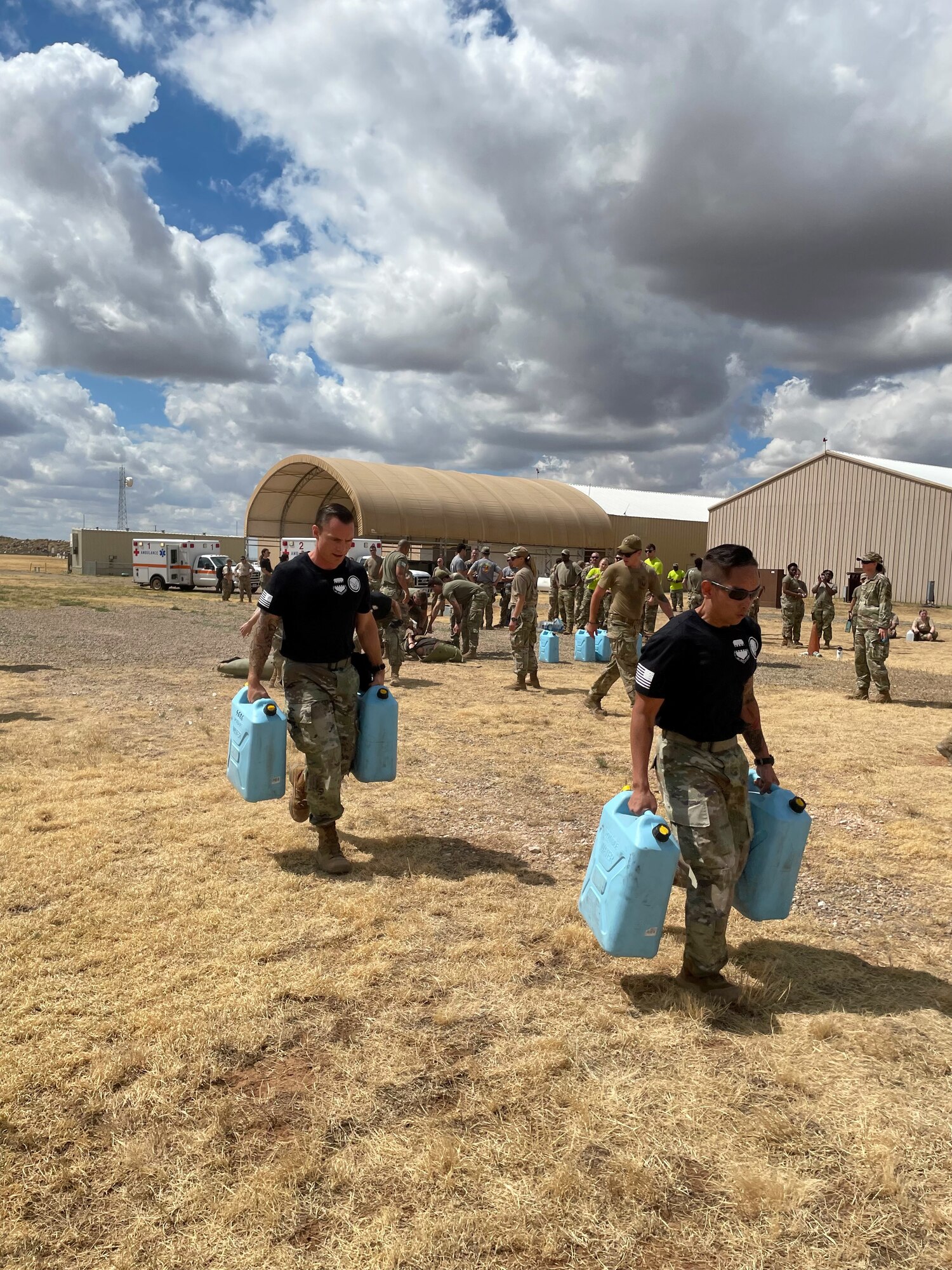 Medics running holding two jugs of water