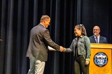 Steve Morgan, superintendent, Shop 38, Marine Machinist, congratulates Jeanoelle Emery, marine machinery mechanic, Shop 38, Marine Machinist, Sept. 29, 2023, during the annual PSNS & IMF Apprentice Program graduation ceremony at Bremerton High School, in Bremerton, Washington.