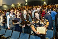 : Shop 26, Welders, apprentice class members (from left) Tyler Reynolds, Millie Stivers, Caitlin Sutter and Monika Westerfield celebrate as they exit the auditorium following the annual Puget Sound Naval Shipyard & Intermediate Maintenance Facility Apprentice Program graduation ceremony Sept. 29, 2023, at the Bremerton High School Performing Arts Center, in Bremerton, Washington.  (U.S. Navy photo by Jeb Fach)