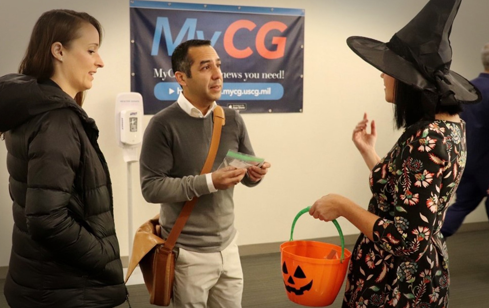 DHS Leader Development Program Manager Alyssa Lombardi (right) handing out Halloween candy to the Coast Guard workforce at headquarters to raise awareness of DHS Leader Grams.