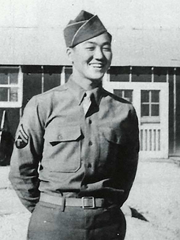 A person in a military uniform smiles.